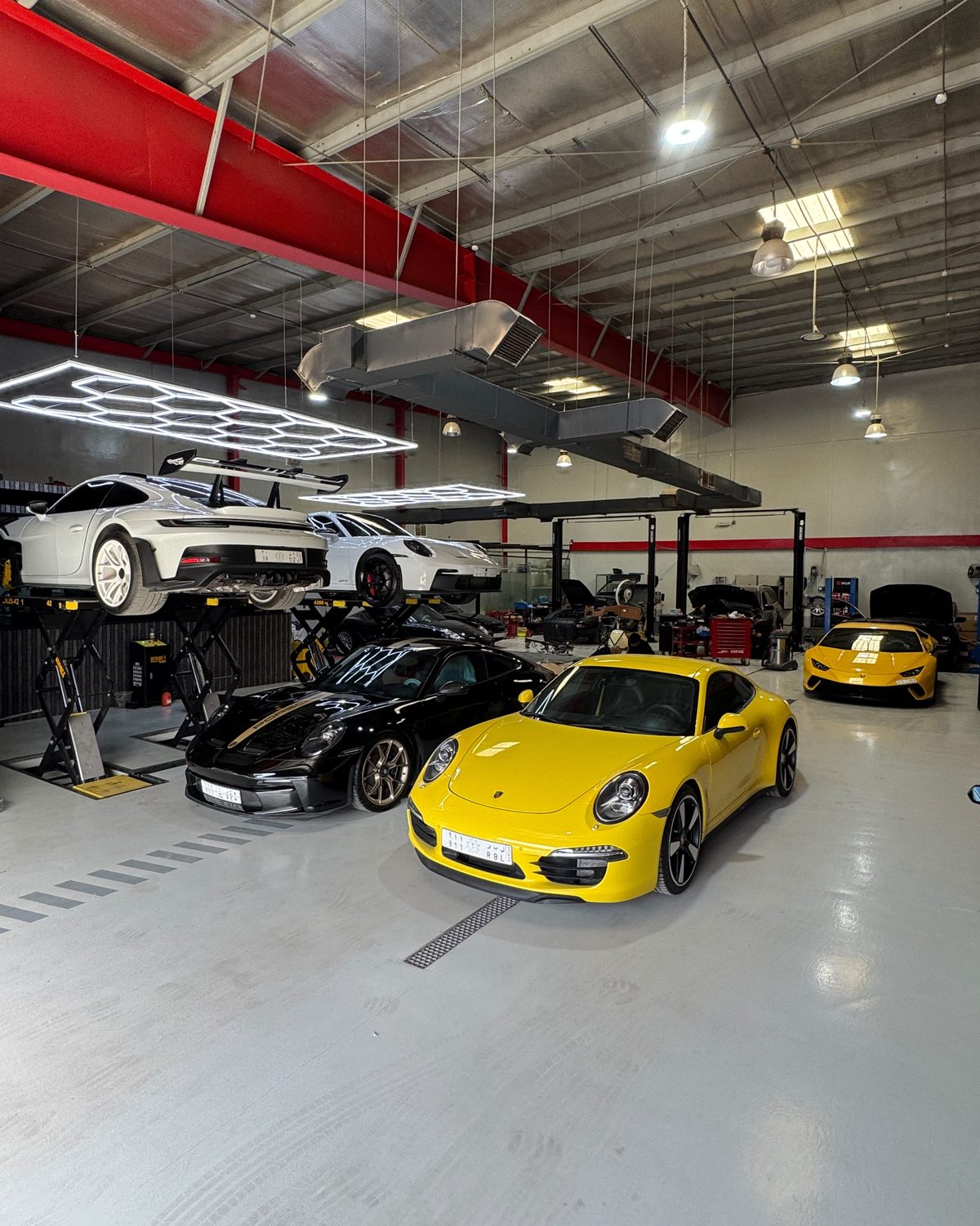 Porsche 911s and a Lamborghini Huracán in the main service bay