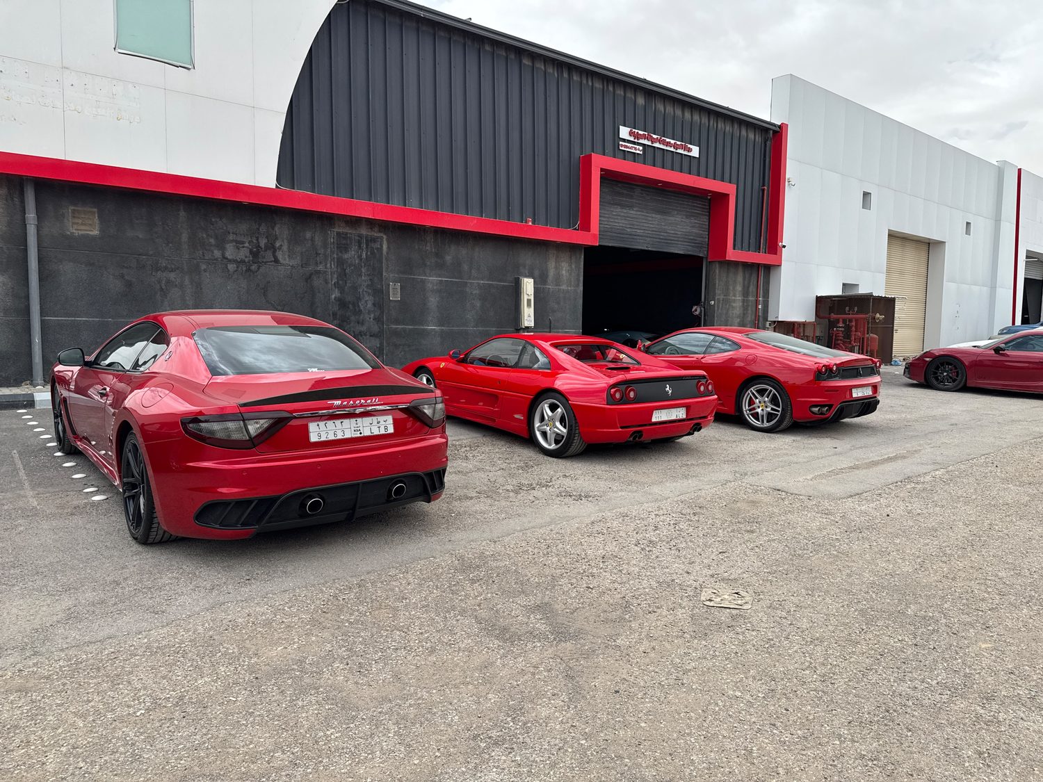 Maserati GranTurismo, Ferrari F355 and F430 parked outside the workshop